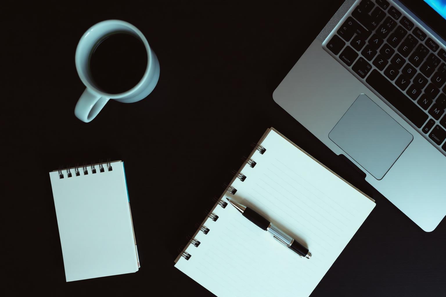 Notebook, pen and laptop on a desk, illustrating practical IT advice and guides from Live IT